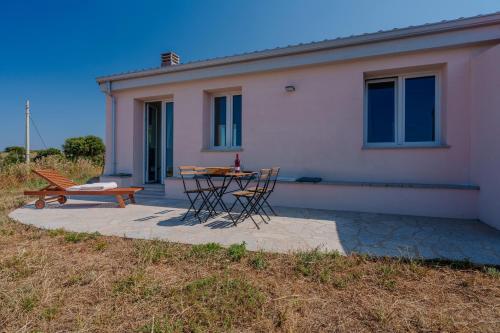 a patio with a table and chairs in front of a house at Il Sughereto In Vigna in Aglientu