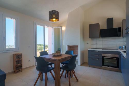 a kitchen with a wooden table and blue chairs at Il Sughereto In Vigna in Aglientu