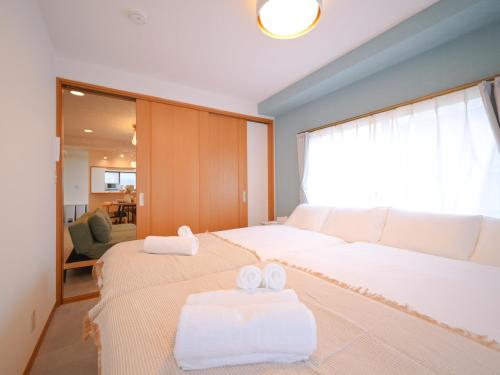 a bedroom with two white towels on a bed at Kiryo Tokyo Kami Itabashi 2 Bedroom Apartment with Kitchen near Ikebukuro in Tokyo