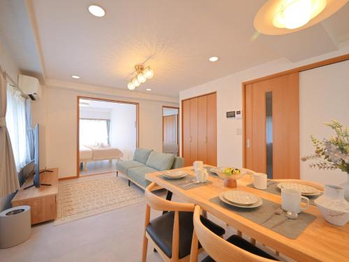 a dining room and living room with a table and a couch at Kiryo Tokyo Kami Itabashi 2 Bedroom Apartment with Kitchen near Ikebukuro in Tokyo