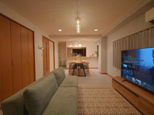 a living room with a couch and a flat screen tv at Kiryo Tokyo Kami Itabashi 2 Bedroom Apartment with Kitchen near Ikebukuro in Tokyo