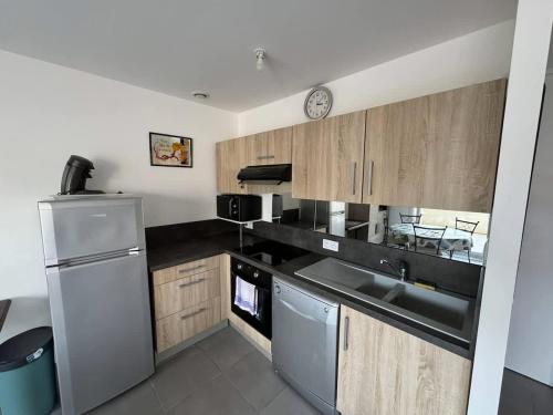 une cuisine avec un évier et un réfrigérateur dans l'établissement Valras Charme & Mer Proche, à Valras-Plage