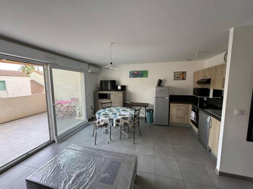 une cuisine et une salle à manger avec une table et des chaises dans l'établissement Valras Charme & Mer Proche, à Valras-Plage