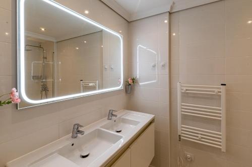 a bathroom with two sinks and a large mirror at Top Floor Ocean View Apt By Dream Homes Tenerife in Puerto de Santiago