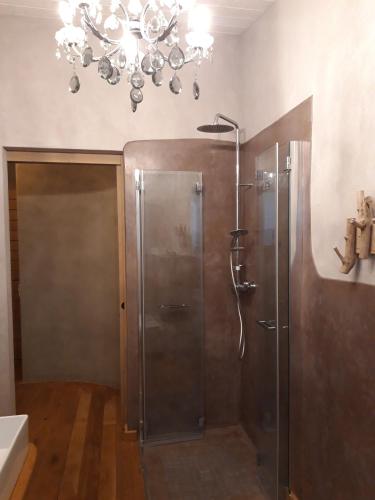 a bathroom with a shower with a chandelier at B&B EcoAntico casa in paglia in Maiolo