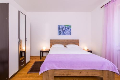 a bedroom with a large bed with purple sheets at Apartment Milka in Krk