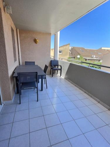 un patio avec une table et des chaises sur un balcon dans l'établissement DESS Ld 104, à Valras-Plage