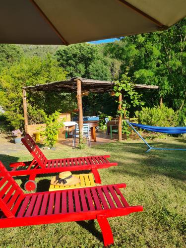 a group of red picnic tables and a playground at Il Laghello Wood House in Framura