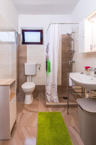 a bathroom with a toilet and a shower and a sink at Apartment Milka in Krk