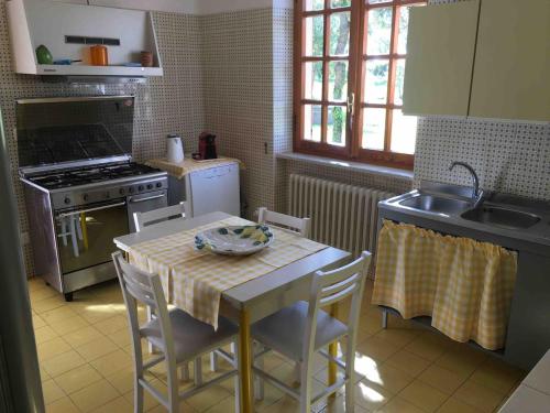 a kitchen with a table with chairs and a sink at Villa Capinera, intera casa con parco privato in Punta Ala