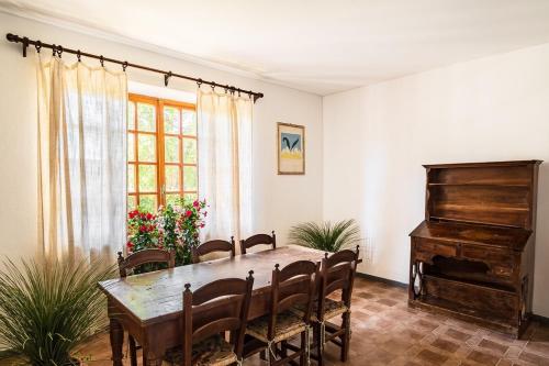 a dining room with a table and a piano at Villa Capinera, intera casa con parco privato in Punta Ala
