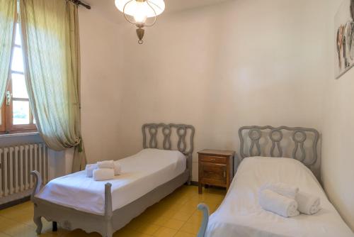 a bedroom with two beds and a window at Villa Capinera, intera casa con parco privato in Punta Ala