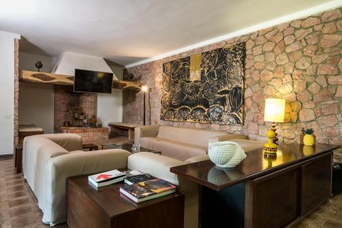 a living room with a couch and a table at Villa Capinera, intera casa con parco privato in Punta Ala