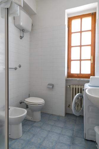 a bathroom with a toilet and a sink at Villa Capinera, intera casa con parco privato in Punta Ala