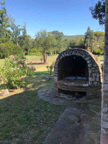 a brick oven in a yard with a field in the background at Villa Capinera, intera casa con parco privato in Punta Ala