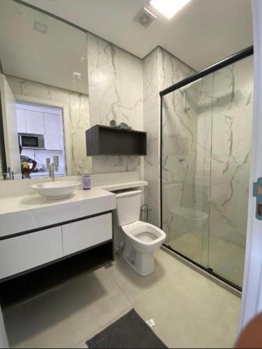 a bathroom with a toilet and a sink and a shower at Studio lindo com ar condicionado e piscina - Bela Vita - 104 in São Lourenço