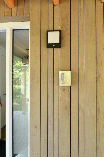a television on a wooden wall next to a door at Villa Maroma Regal luxueus verblijf voor zakelijk en privé met gratis 4 E-bikes in Kamperland