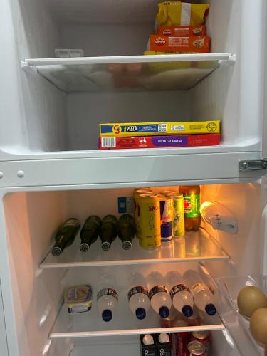 an open refrigerator filled with food and drinks at Loft lindo e aconchegante! in Toritama
