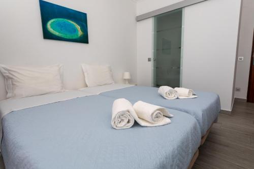 a bedroom with a bed with towels on it at Residencia Salva-Vidas in Nazaré