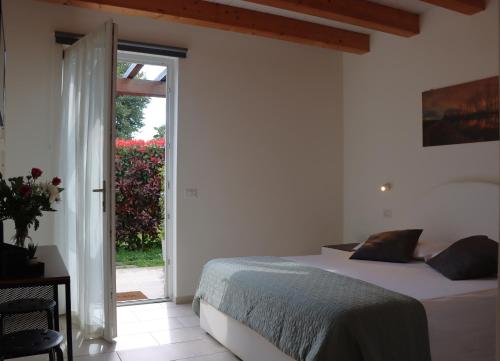 a bedroom with a bed and a sliding glass door at Il Toscanello in Lido di Camaiore