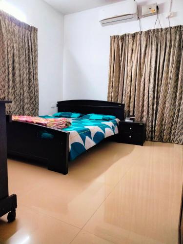 a bedroom with a bed in a room with curtains at Gripzy Serene Abode-Kazhakuttam in Trivandrum