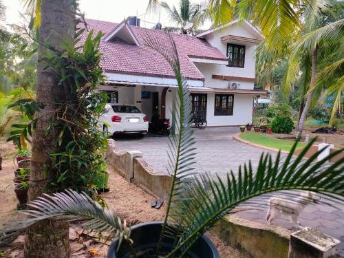 a white car parked in front of a house at Gripzy Serene Abode-Kazhakuttam in Trivandrum