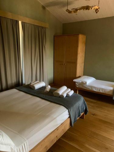 a bedroom with a large bed with towels on it at B&B EcoAntico casa in paglia in Maiolo