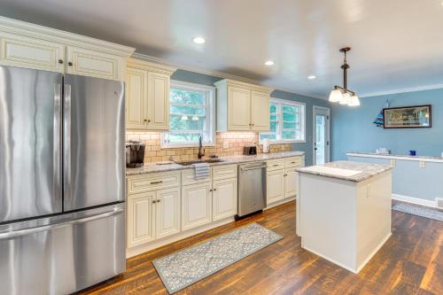 a kitchen with white cabinets and a stainless steel refrigerator at 3 Mi to Pro Football Hall of Fame Home with Yard! in Canton