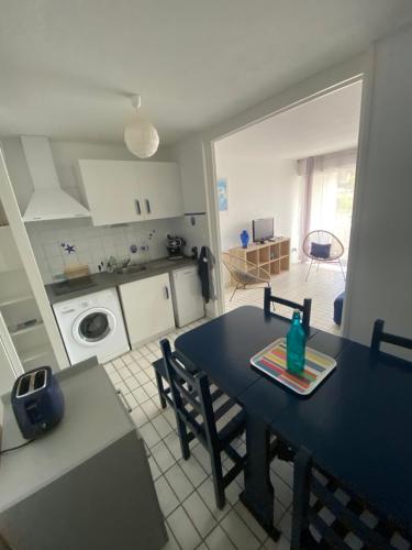 une cuisine et une salle à manger avec une table bleue et des chaises dans l'établissement Appartement à la Grande Motte à 50m de la plage, à La Grande Motte