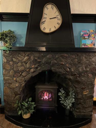 a clock above a fireplace with a fire place at The Drovers Arms Hotel in Carmarthen