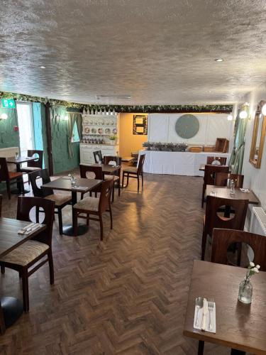 a restaurant with wooden tables and chairs and a counter at The Drovers Arms Hotel in Carmarthen