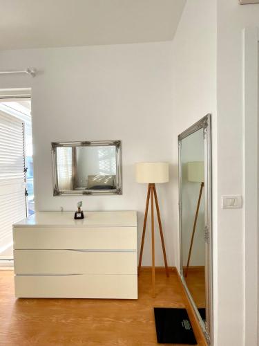 eine Kommode mit einem Spiegel und einer Lampe im Zimmer in der Unterkunft Crystal Pool Villa Bay of Lalzi in Draç