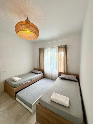 ein Schlafzimmer mit zwei Betten und einem Kronleuchter in der Unterkunft Crystal Pool Villa Bay of Lalzi in Draç