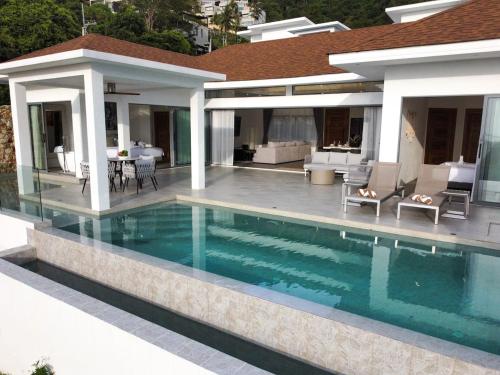 a swimming pool in front of a house at Villa Lulu Chic 2BR Seaview Retreat Private Pool in Ban Lamai