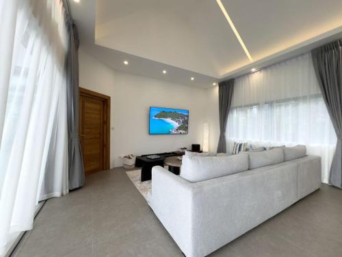 a living room with a white couch and a desk at Villa Lulu Chic 2BR Seaview Retreat Private Pool in Ban Lamai
