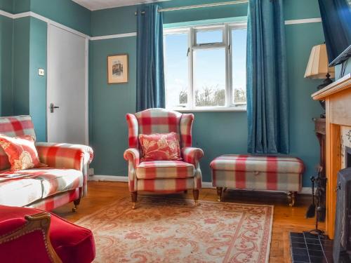 a living room with two chairs and a window at Heath View in Saxmundham