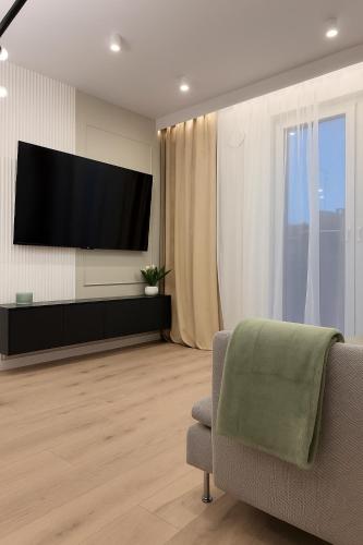 a living room with a flat screen tv on a wall at Slovianka Residence in Łódź