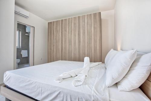 una cama blanca con sábanas y almohadas blancas en Mercury Residence No15 Penthouse Terrace by Haven & Keys Malta, en Sliema