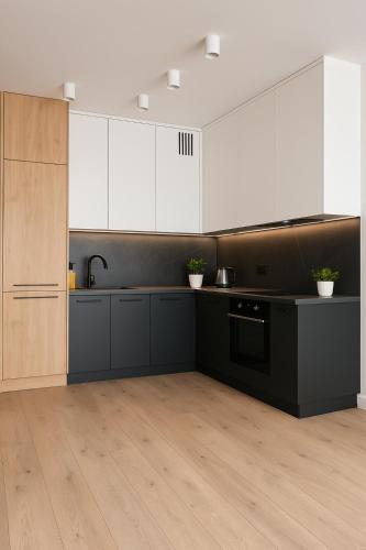 a kitchen with black counters and white cabinets at Slovianka Residence in Łódź