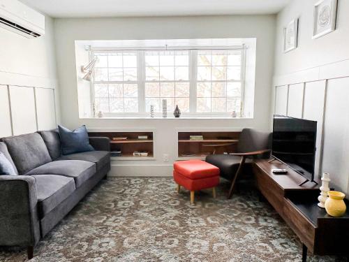 a living room with a gray couch and a window at The 4M Golden House - Central Location Beautiful Space & Neighborhood in Ann Arbor