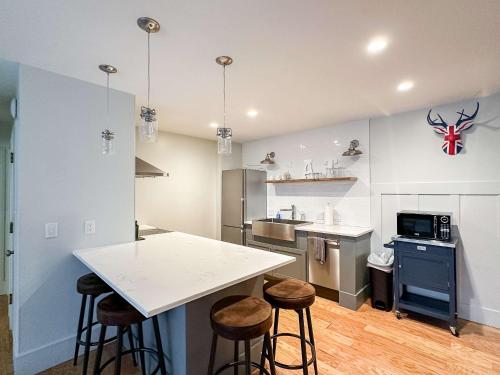 a kitchen with a white counter and bar stools at The 4M Golden House - Central Location Beautiful Space & Neighborhood in Ann Arbor