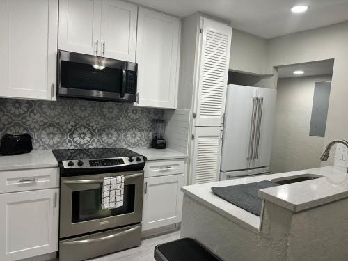 a kitchen with white cabinets and stainless steel appliances at Casita San Juan in Jacksonville