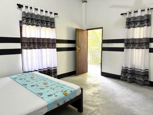 1 dormitorio con 1 cama y una puerta con cortinas en Holiday In Nilaveli Resort, en Trincomalee