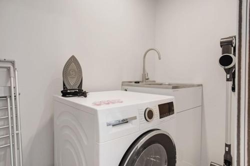 a washing machine in a room with a sink at Modern Townhouse close to Airport and Hospital in Auckland