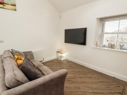 a living room with a couch and a flat screen tv at Lakes View Apartment 2 in Carnforth