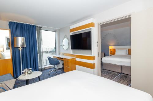 a hotel room with a bed and a desk at DoubleTree by Hilton Hotel London - Tower of London in London