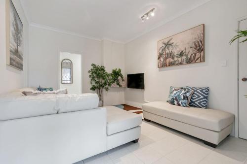 a white living room with two white couches at 9-3 Glenelg Place Connolly A9 Elegant 3 bed apt in the heart of Connolly in Perth