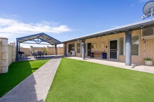 a patio with green grass next to a house at 9-3 Glenelg Place Connolly A9 Elegant 3 bed apt in the heart of Connolly in Perth