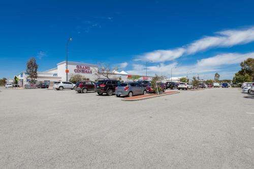 a parking lot with cars parked in front of a store at 9-3 Glenelg Place Connolly A9 Elegant 3 bed apt in the heart of Connolly in Perth