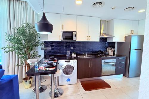 a kitchen with a washer and a dishwasher at Blue Seaview 75 inch Smart TV 1Br in Manama